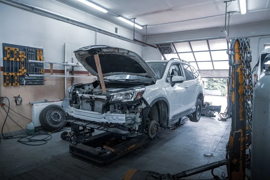 Biały SUV podczas naprawy przodu na ramie